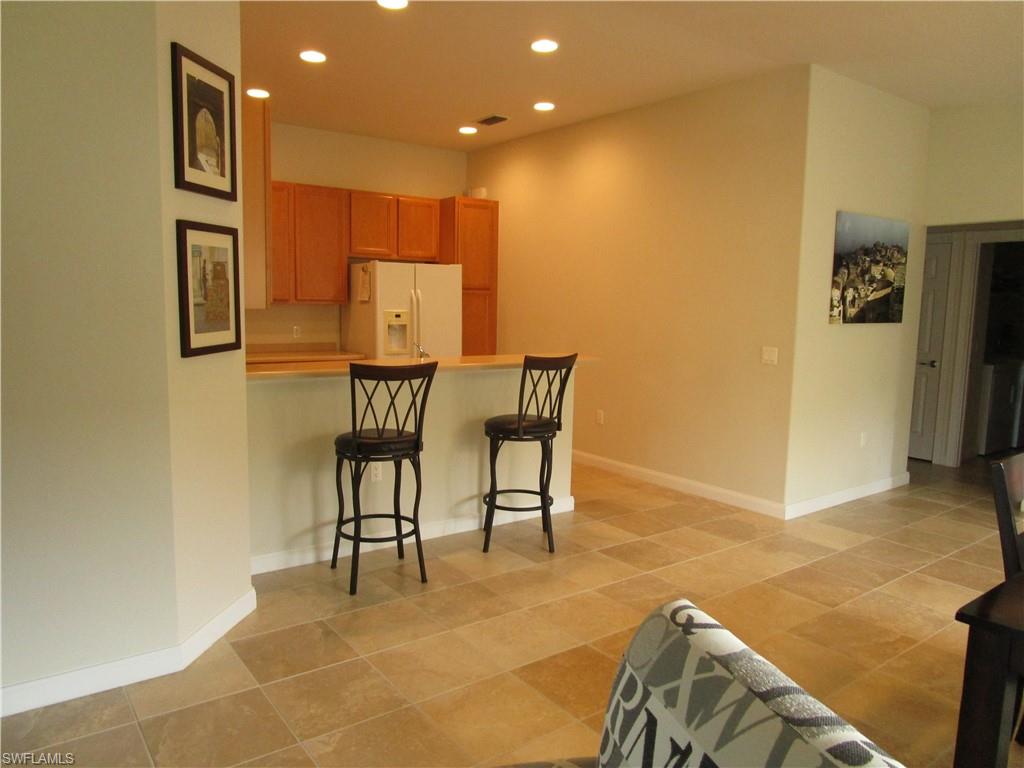 8677 Erice Court Naples, FL 34114 - Photo 29 of 42 a view of a livingroom with furniture and a kitchen