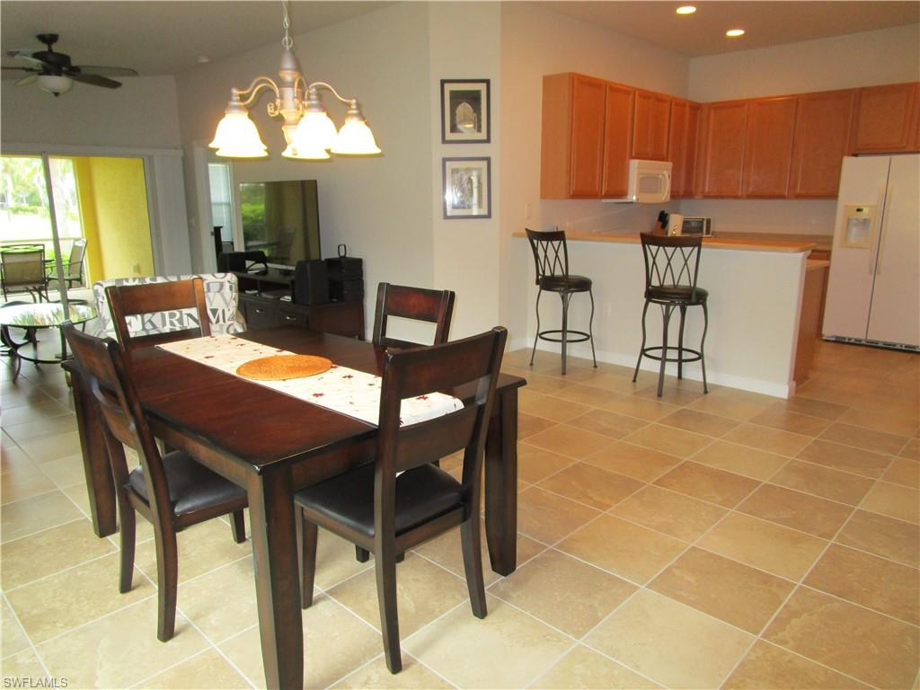 8677 Erice Court Naples, FL 34114 - Photo 30 of 42 a view of a dining room with furniture and a chandelier