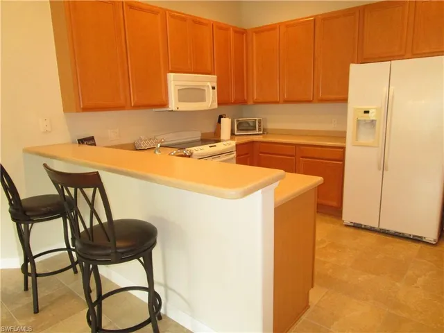 a view of a dining room and livingroom with furniture wooden floor a rug a fireplace and a large window