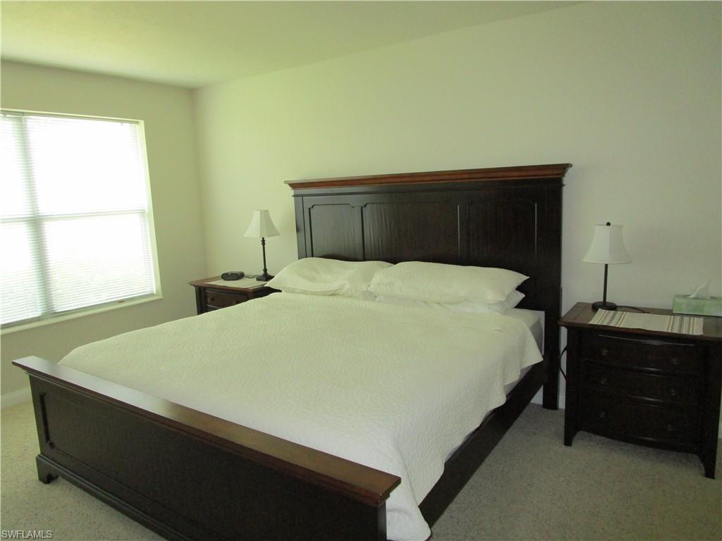 8677 Erice Court Naples, FL 34114 - Photo 34 of 42 a bed sitting in a bedroom next to a window