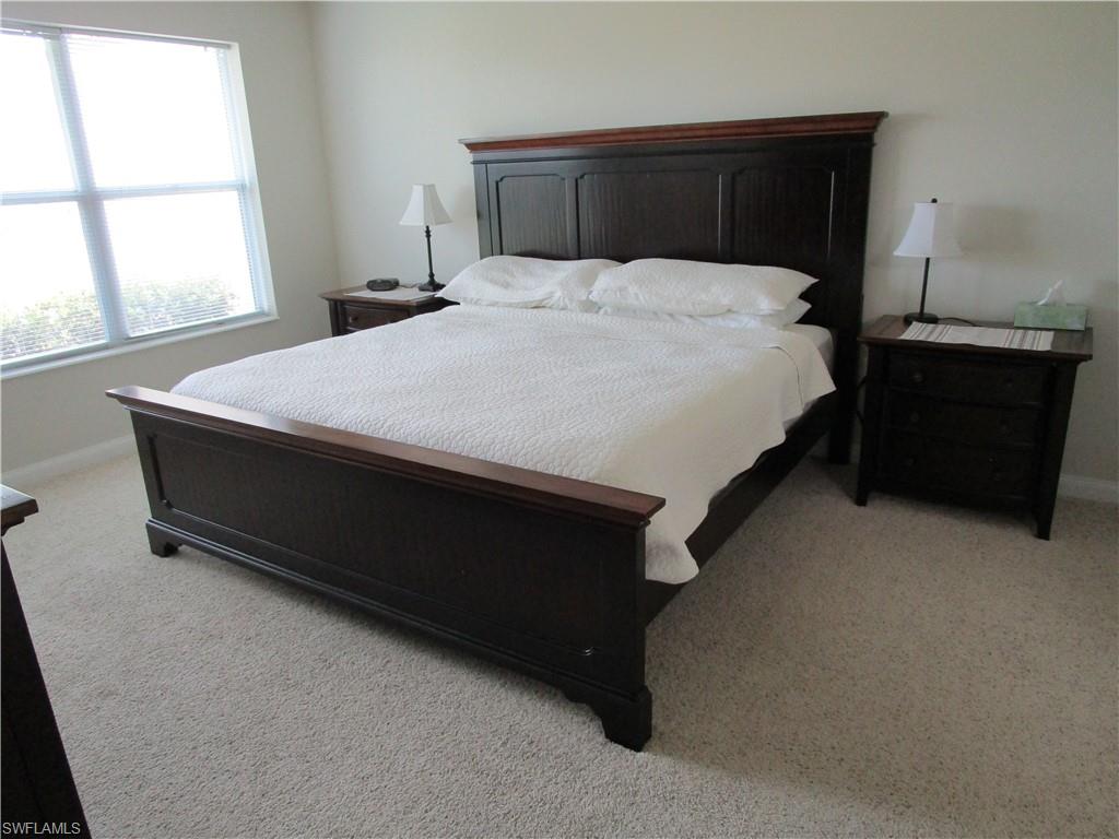 8677 Erice Court Naples, FL 34114 - Photo 8 of 42 Bedroom with light carpet and baseboards