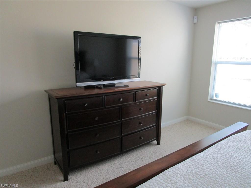 8677 Erice Court Naples, FL 34114 - Photo 9 of 42 a room with furniture and flat screen tv