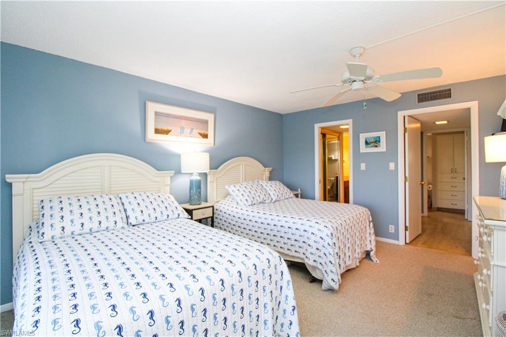 1 Bluebill Avenue, Unit 501 Naples, FL 34108 - Photo 15 of 38 a bedroom with two beds and a lamp