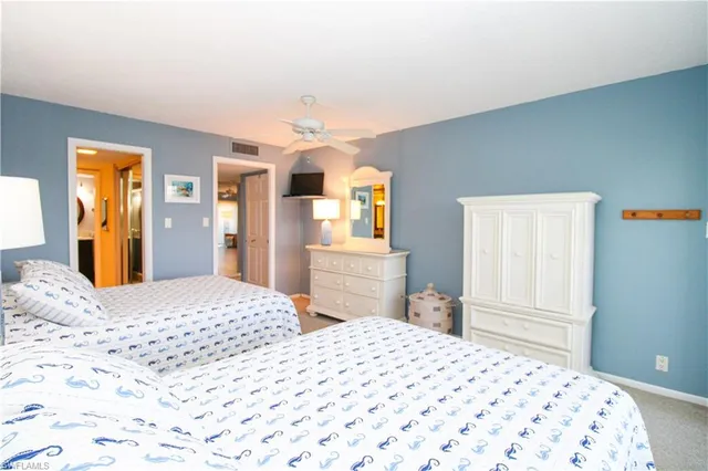 a bedroom with two beds and a lamp