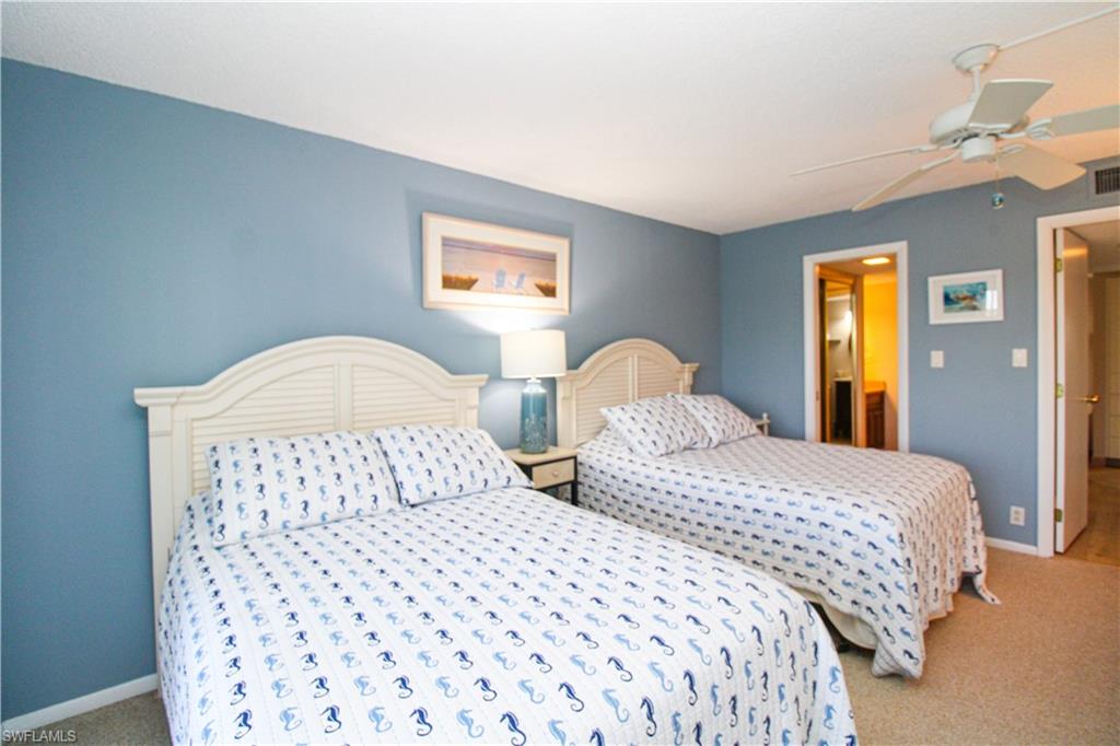 1 Bluebill Avenue, Unit 501 Naples, FL 34108 - Photo 18 of 38 a bedroom with two beds and a dresser