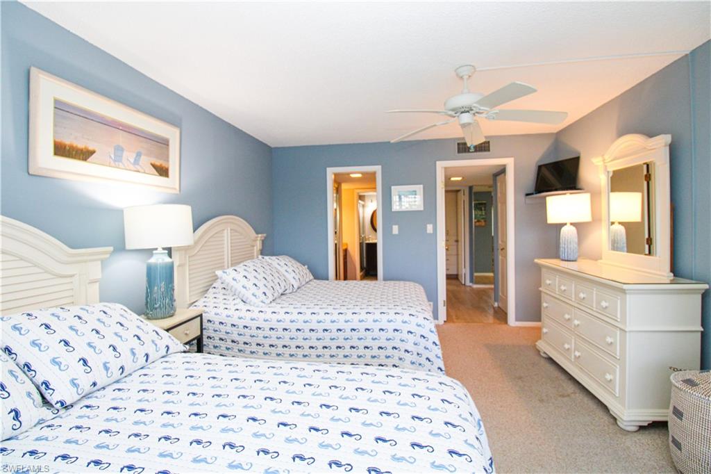 1 Bluebill Avenue, Unit 501 Naples, FL 34108 - Photo 19 of 38 a bedroom with two beds and a dresser