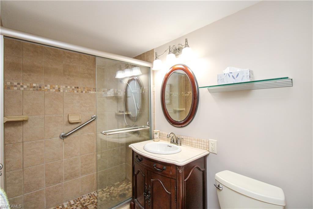 1 Bluebill Avenue, Unit 501 Naples, FL 34108 - Photo 21 of 38 a bathroom with a sink a toilet and a mirror