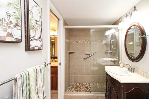 a bathroom with a granite countertop sink vanity and mirror