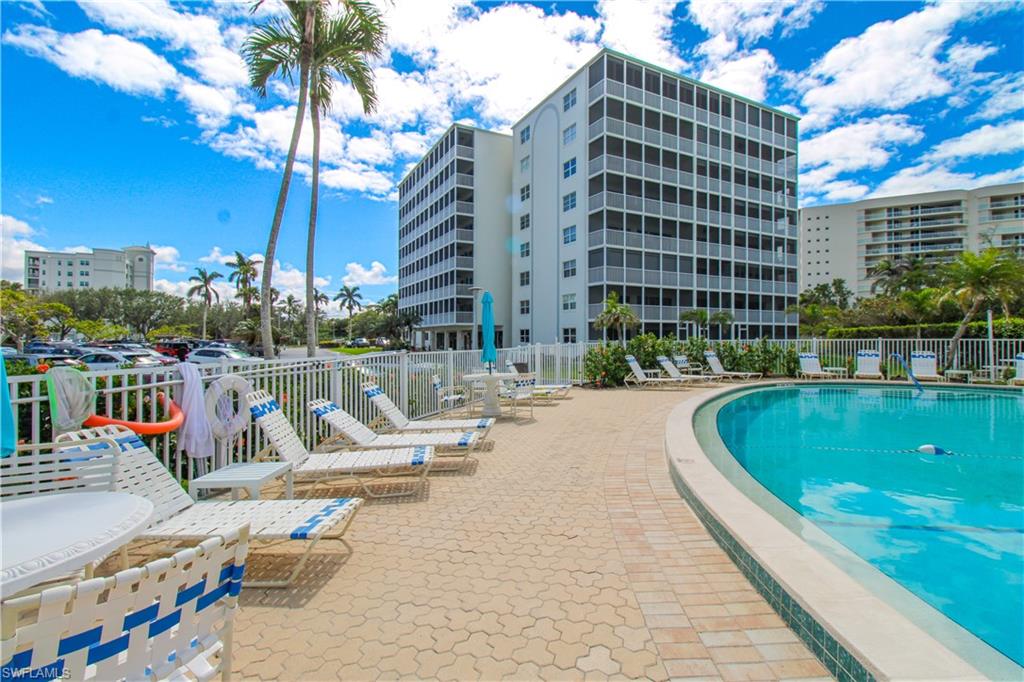1 Bluebill Avenue, Unit 501 Naples, FL 34108 - Photo 31 of 38 a view of a swimming pool with a lounge chairs
