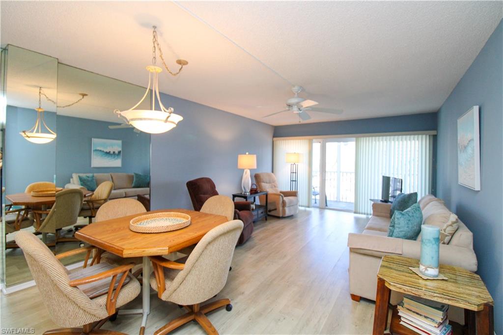 1 Bluebill Avenue, Unit 501 Naples, FL 34108 - Photo 8 of 38 a living room with furniture a chandelier and a dining table
