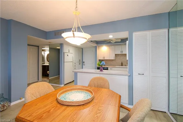 a kitchen with stainless steel appliances granite countertop a sink a stove a dining table and chairs with wooden floor