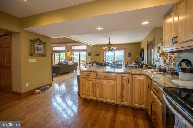 a large kitchen with stainless steel appliances a large counter top a stove and a wooden floors