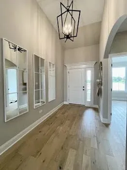 a view of empty room with wooden floor and door