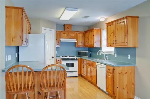 a kitchen with stainless steel appliances granite countertop a stove a sink dishwasher and a refrigerator