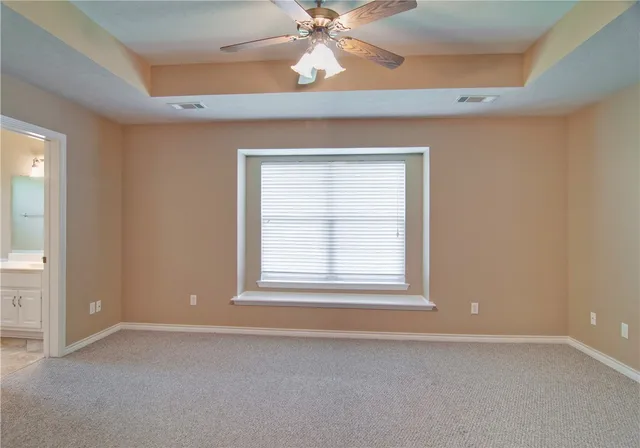 an empty room with a window and a fan