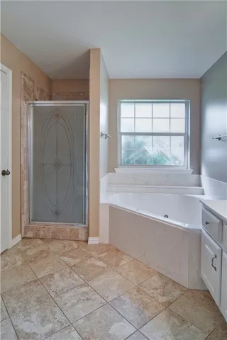a spacious bathroom with a tub shower and sink