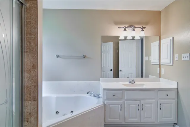 a bathroom with a bathtub sink and mirror