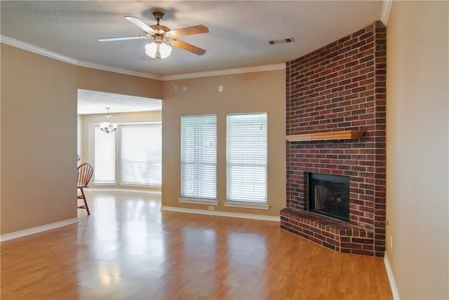 a view of empty room with wooden floor and fireplace