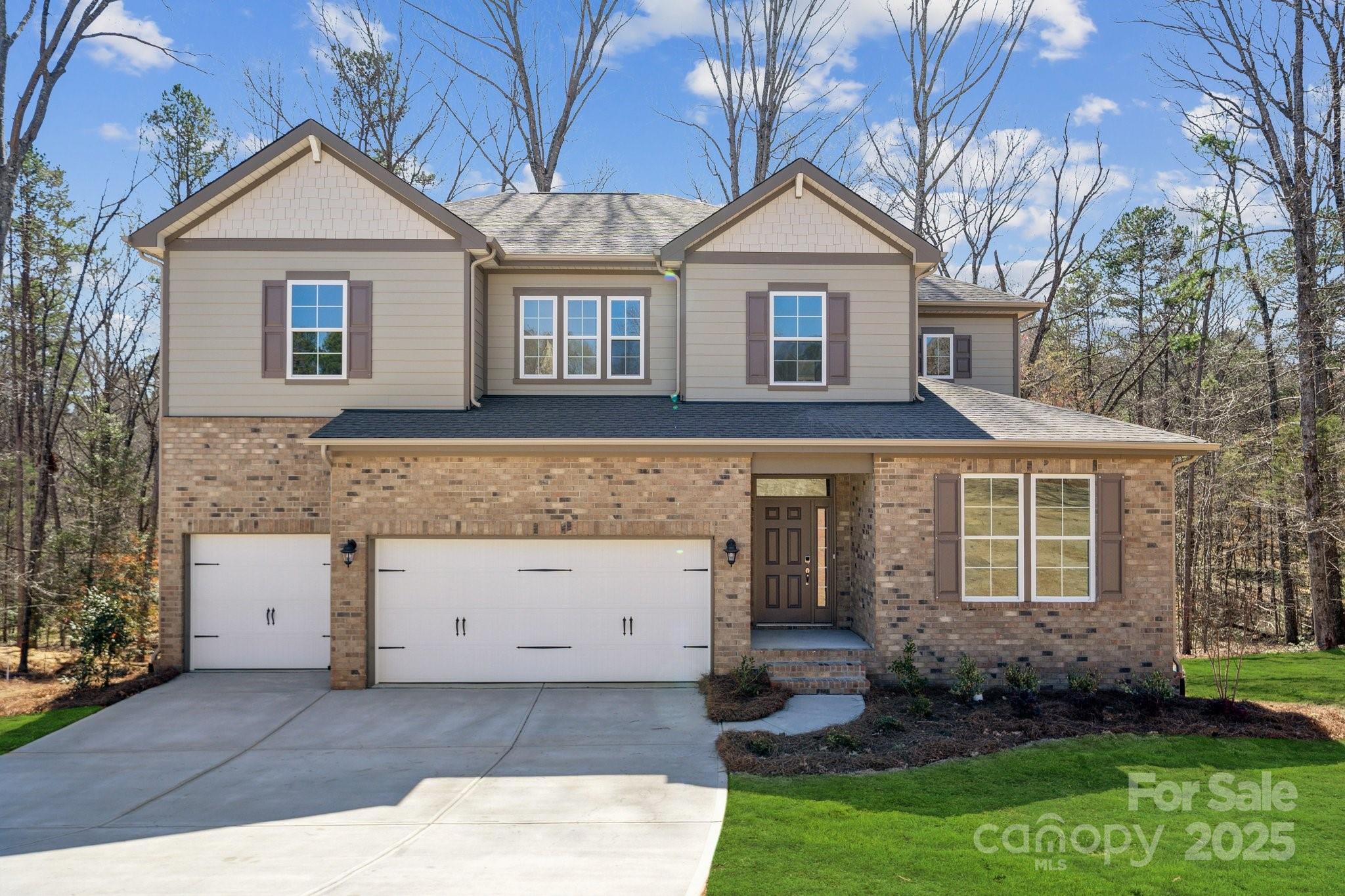 a view of a big house with plants and a yard