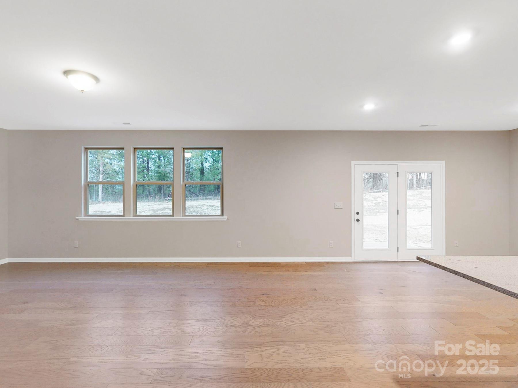 7089 Cobblefield Lane Denver, NC 28037 - Photo 14 of 36 an empty room with wooden floor and windows