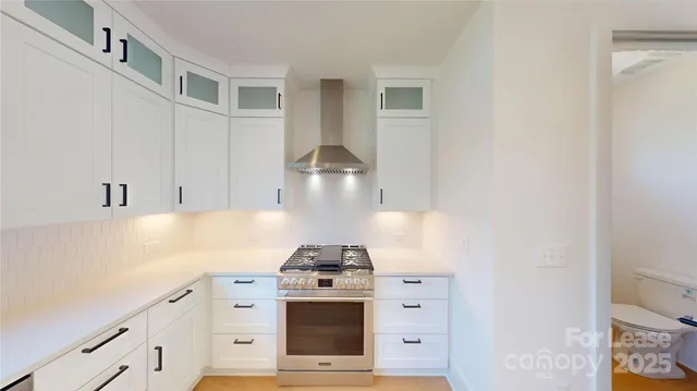 a kitchen with stainless steel appliances white cabinets and a stove