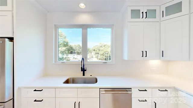 a kitchen with white cabinets and stainless steel appliances