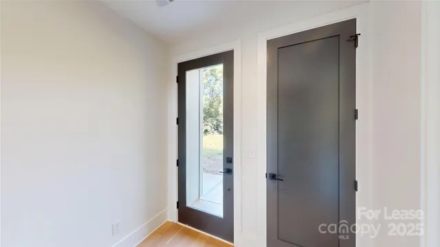 a view of hallway with a large window and wooden floor