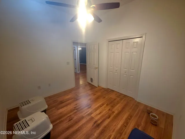a view of empty room with wooden floor