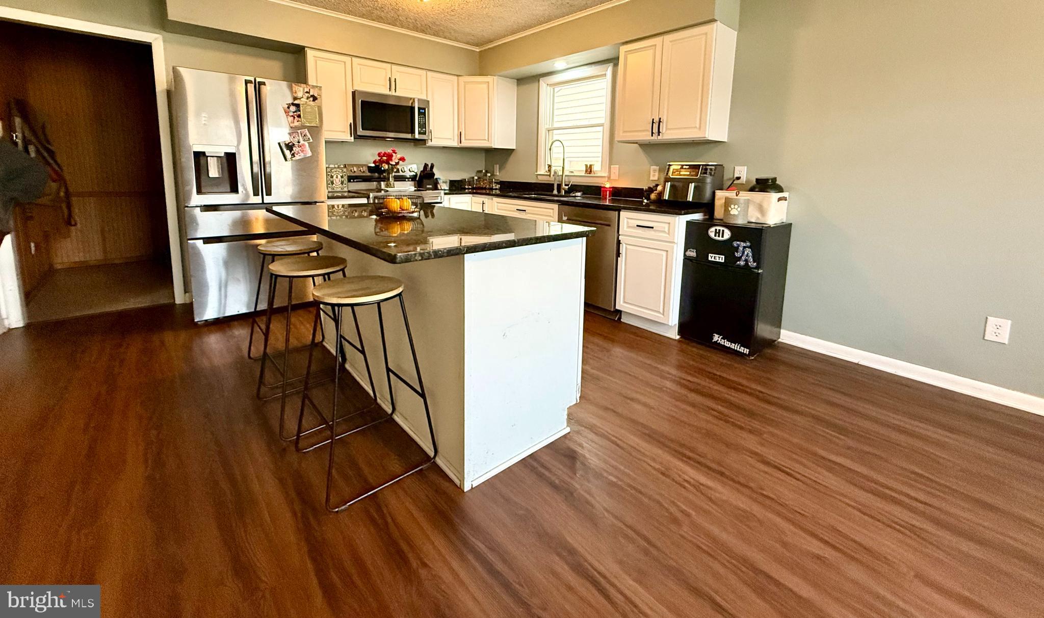 38 South Carter Road Smyrna, DE 19977 - Photo 2 of 30 a kitchen with stainless steel appliances granite countertop a stove top oven a sink dishwasher and a refrigerator with wooden floor