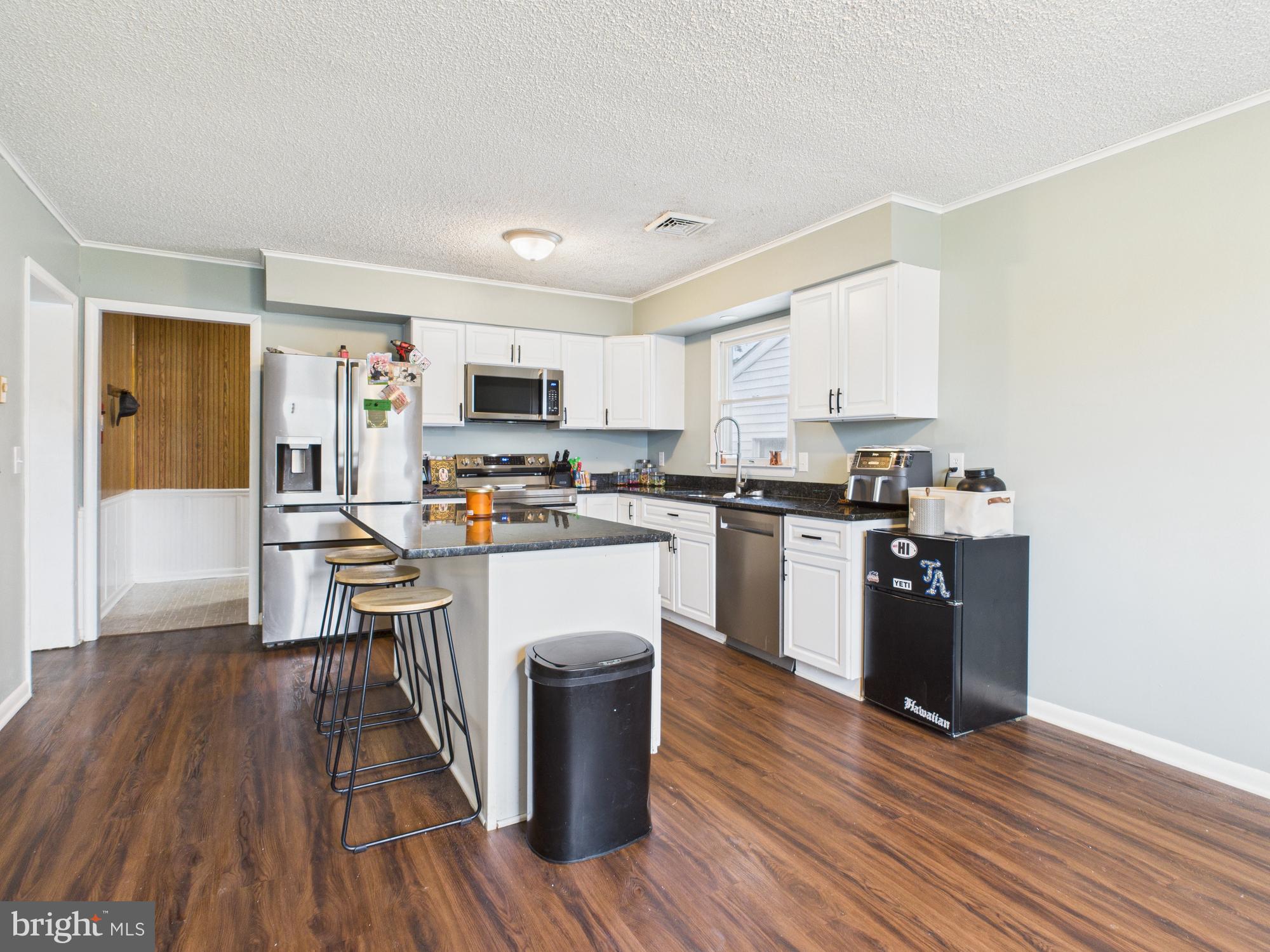 38 South Carter Road Smyrna, DE 19977 - Photo 27 of 30 a kitchen with granite countertop wooden floors stainless steel appliances and sink