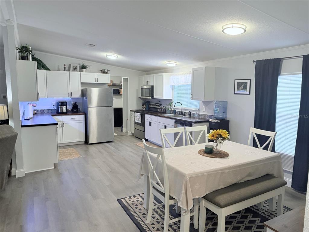 900 Racoon Trail Frostproof, FL 33843 - Photo 11 of 25 a kitchen with a sink a refrigerator and wooden floor
