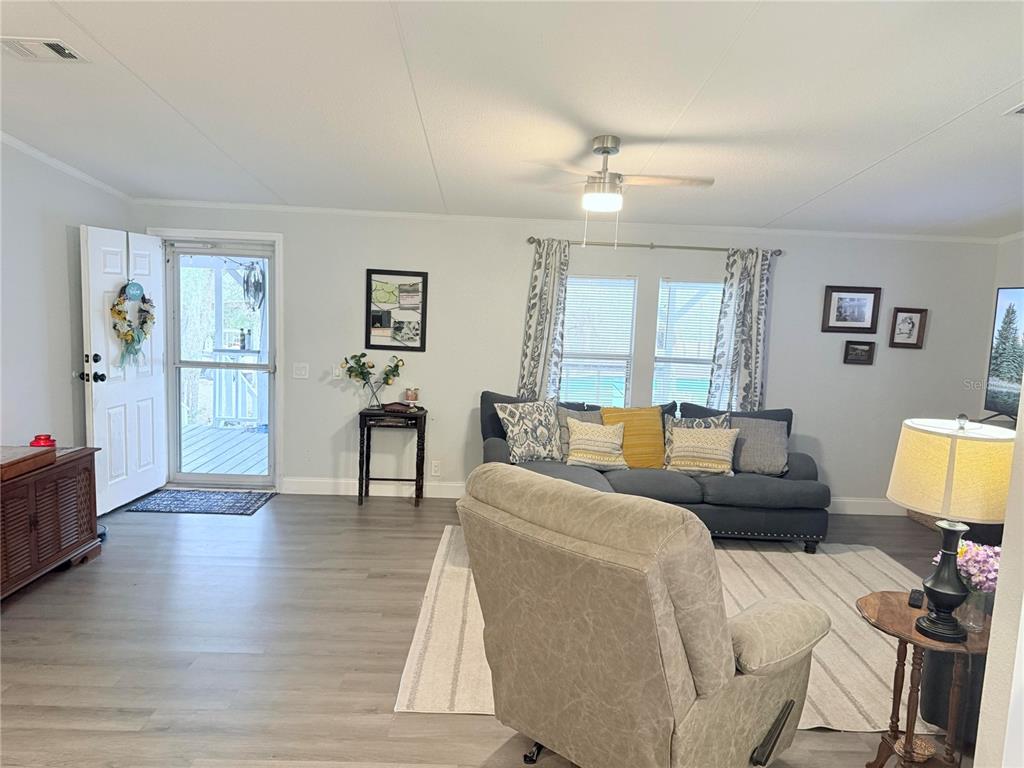 900 Racoon Trail Frostproof, FL 33843 - Photo 12 of 25 a living room with furniture a large window and a wooden floor