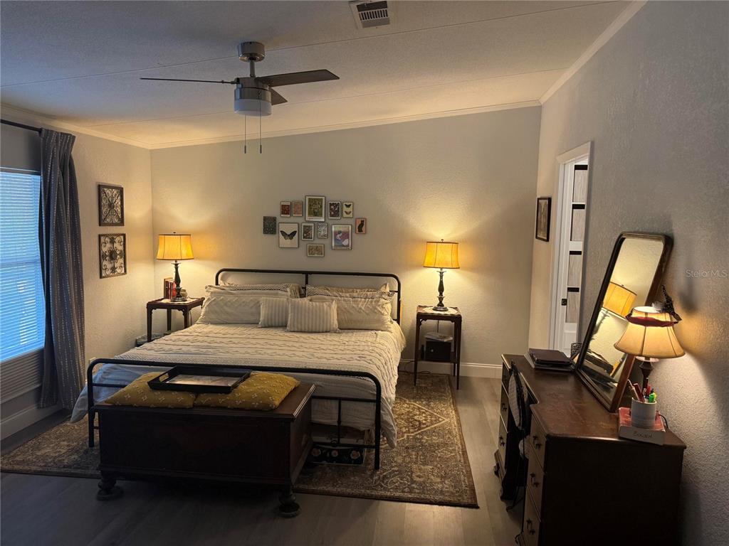 900 Racoon Trail Frostproof, FL 33843 - Photo 14 of 25 a bedroom with a bed and wooden floor