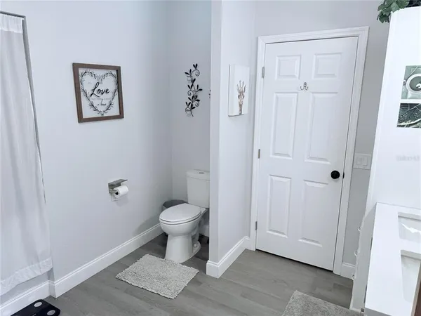 a bedroom with a bed and a lamp on the dresser