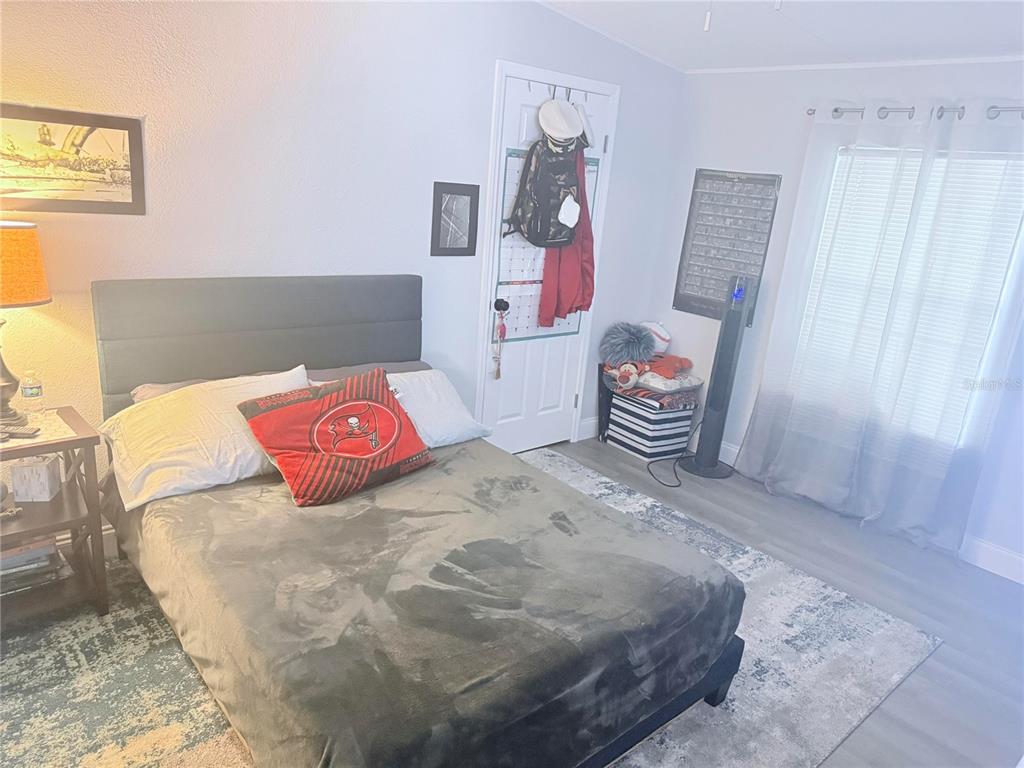 900 Racoon Trail Frostproof, FL 33843 - Photo 19 of 25 a bedroom with a bed and a chair in it