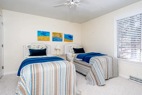 a bedroom with two beds and a chandelier