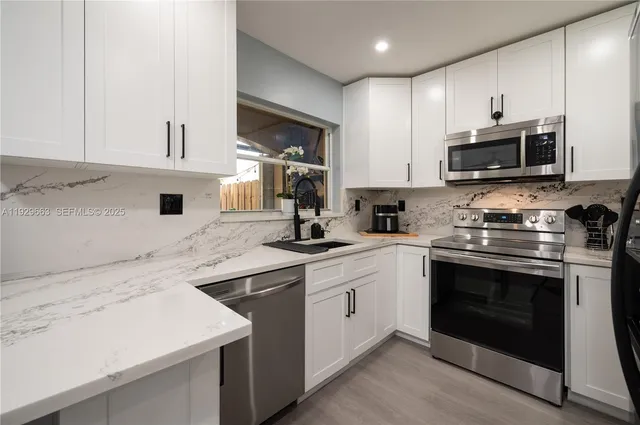 a kitchen with stainless steel appliances granite countertop a stove a sink and a refrigerator