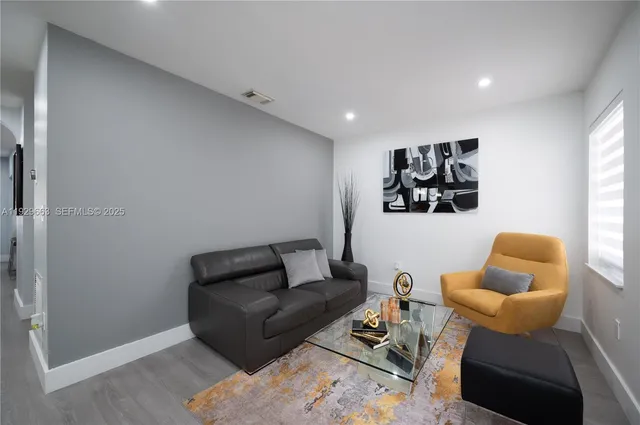 a living room with furniture a rug and a window