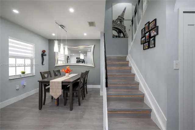 a living room with stainless steel appliances furniture a rug and a window
