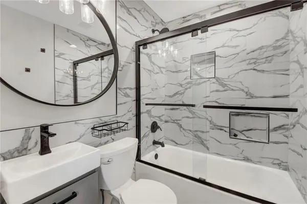 a bathroom with a sink toilet a mirror and shower