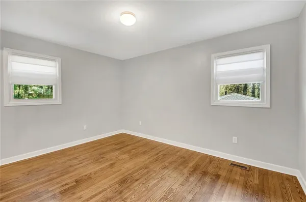 a view of empty room with wooden floor
