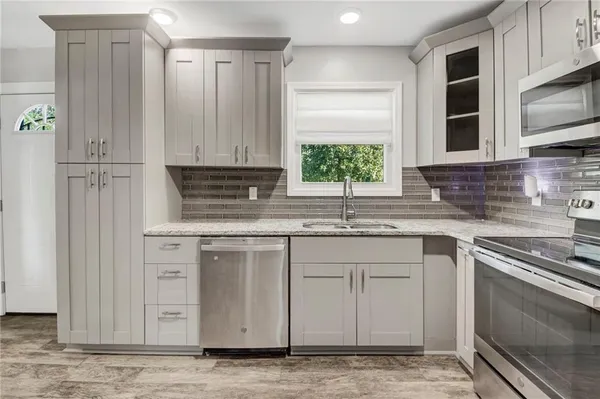 a kitchen with stainless steel appliances granite countertop a sink a stove and a microwave