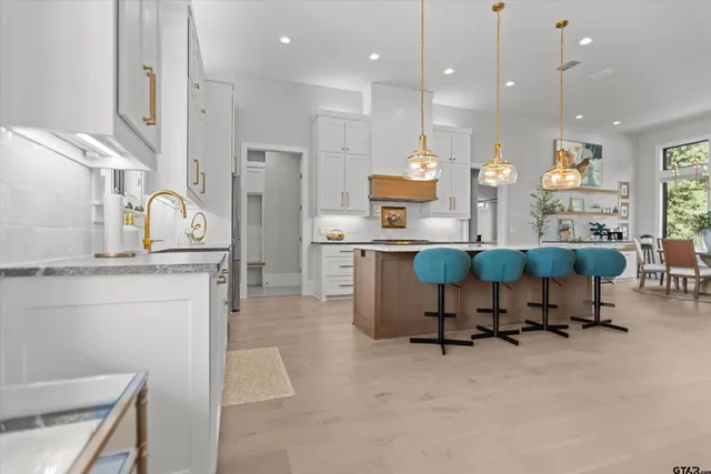 a living room with furniture a rug kitchen kitchen view and a chandelier