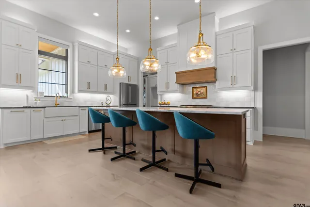 a kitchen with cabinets and chairs