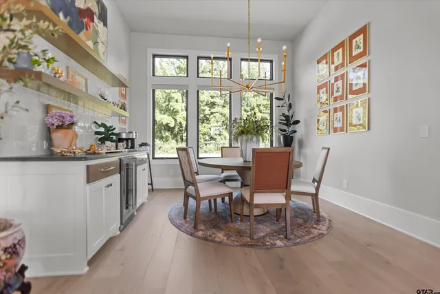 a dining room with furniture a chandelier and window