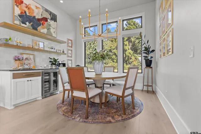 a dining room with furniture a chandelier and window