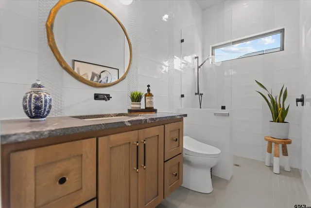 a bathroom with a toilet a sink and a mirror