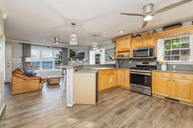 a kitchen with stainless steel appliances granite countertop a sink a stove and a microwave