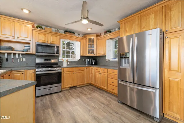 a large kitchen with stainless steel appliances granite countertop a stove and a sink
