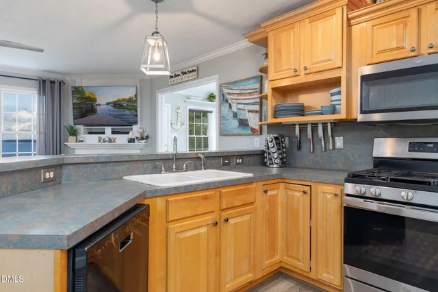 a kitchen with stainless steel appliances kitchen island granite countertop a refrigerator a stove a sink dishwasher a dining table and chairs with wooden floor